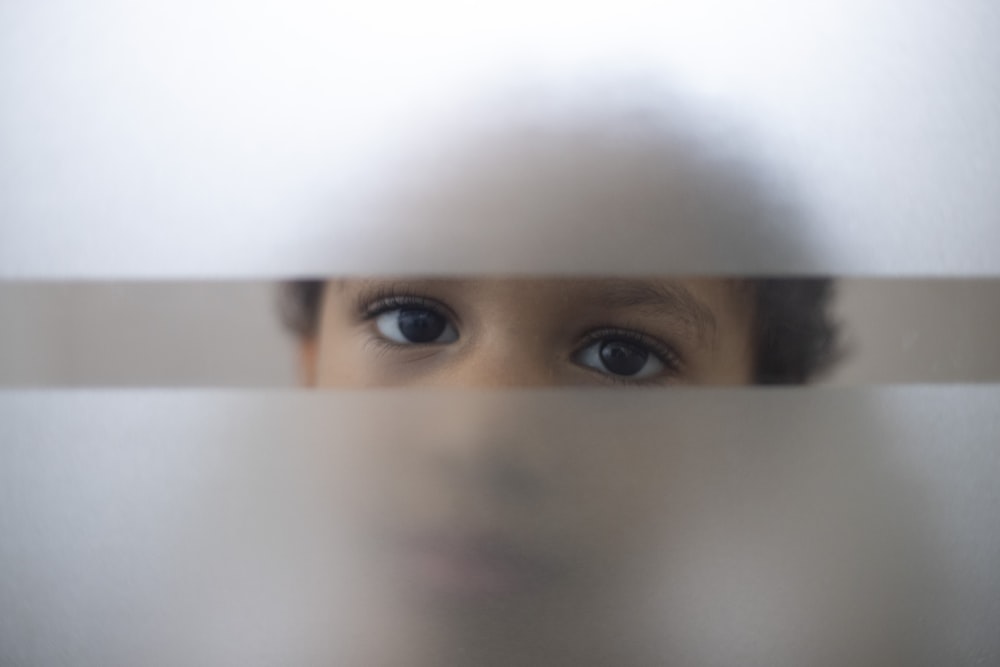 a young child looking through a glass window