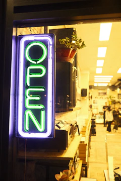 An entrepreneur proudly opening the doors of a new local shop with community members gathered outside.