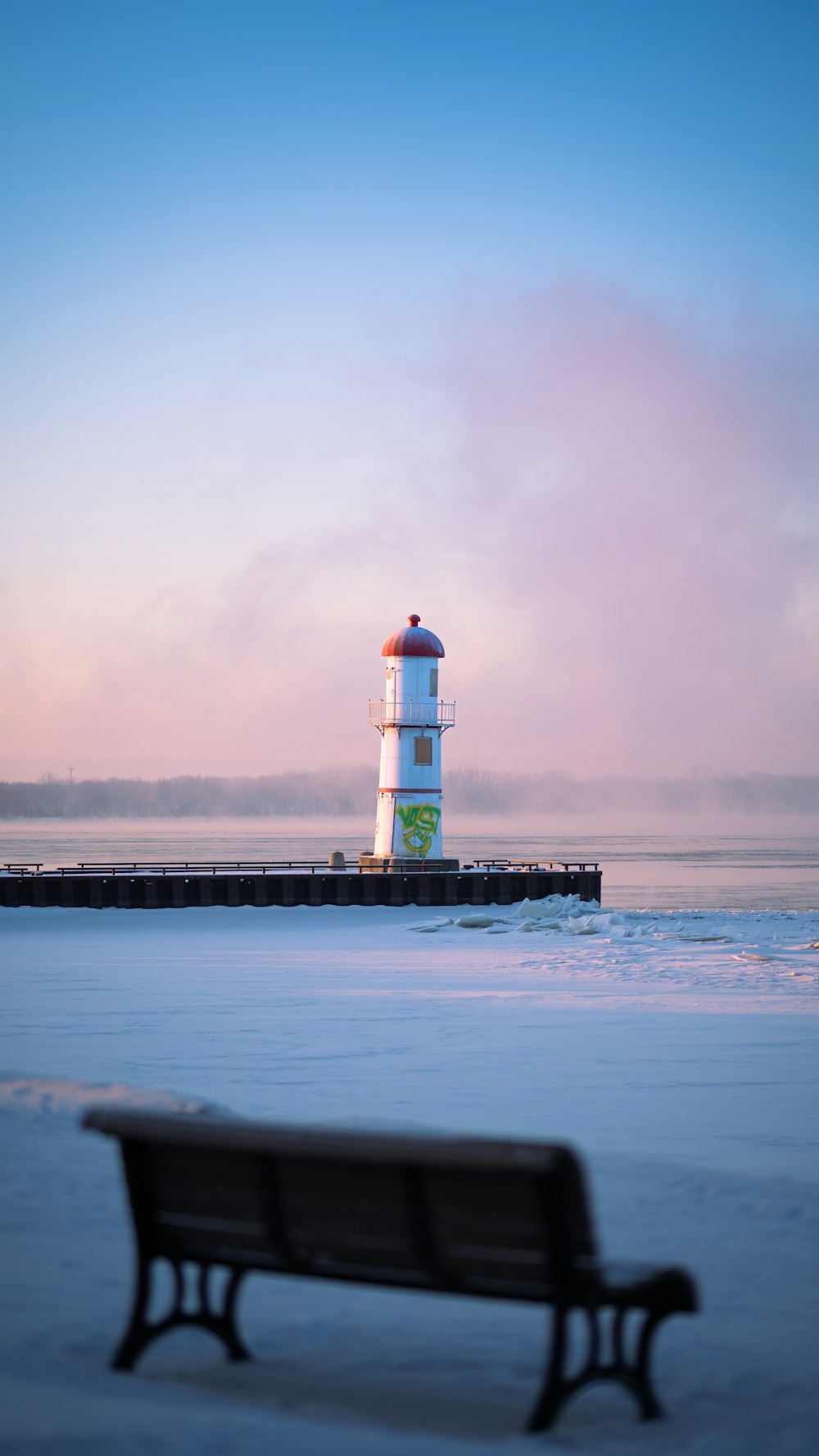 a bench sitting in front of a light house