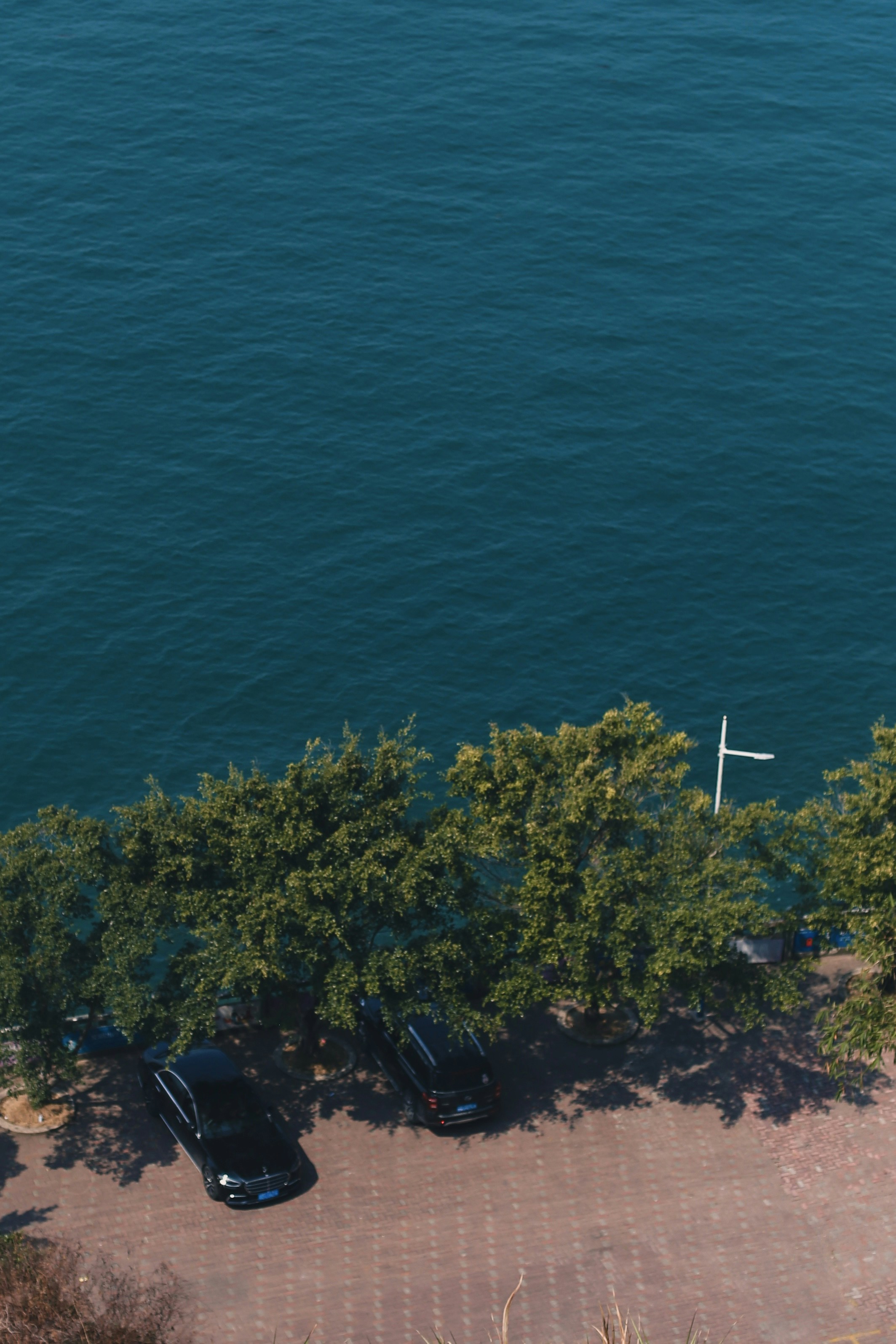 an aerial view of a parking lot next to a body of water