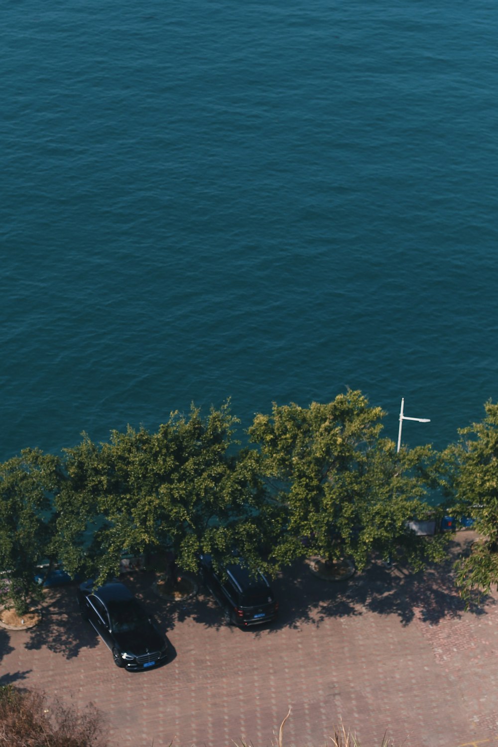 an aerial view of a parking lot next to a body of water