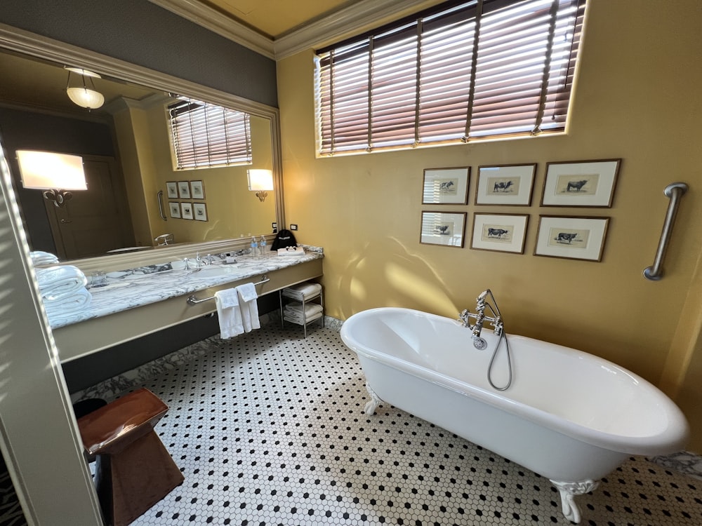 a bathroom with a bathtub, sink, and mirror