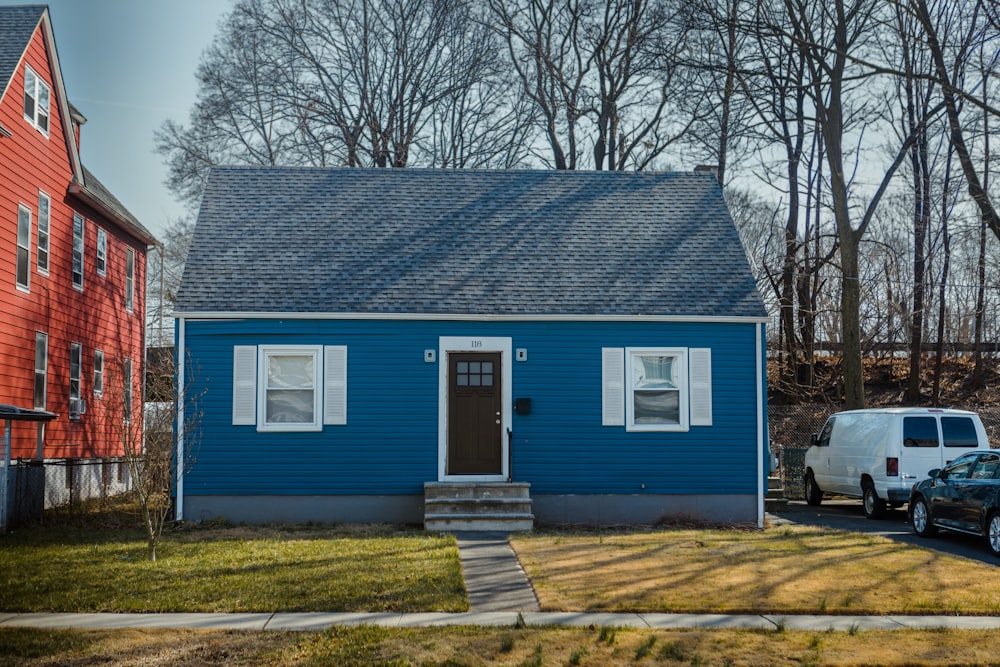 a blue house with a white truck parked in front of it