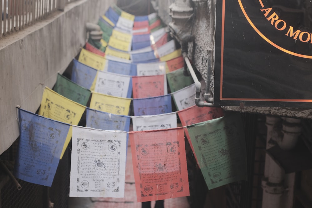 a long row of colorful papers hanging from a building