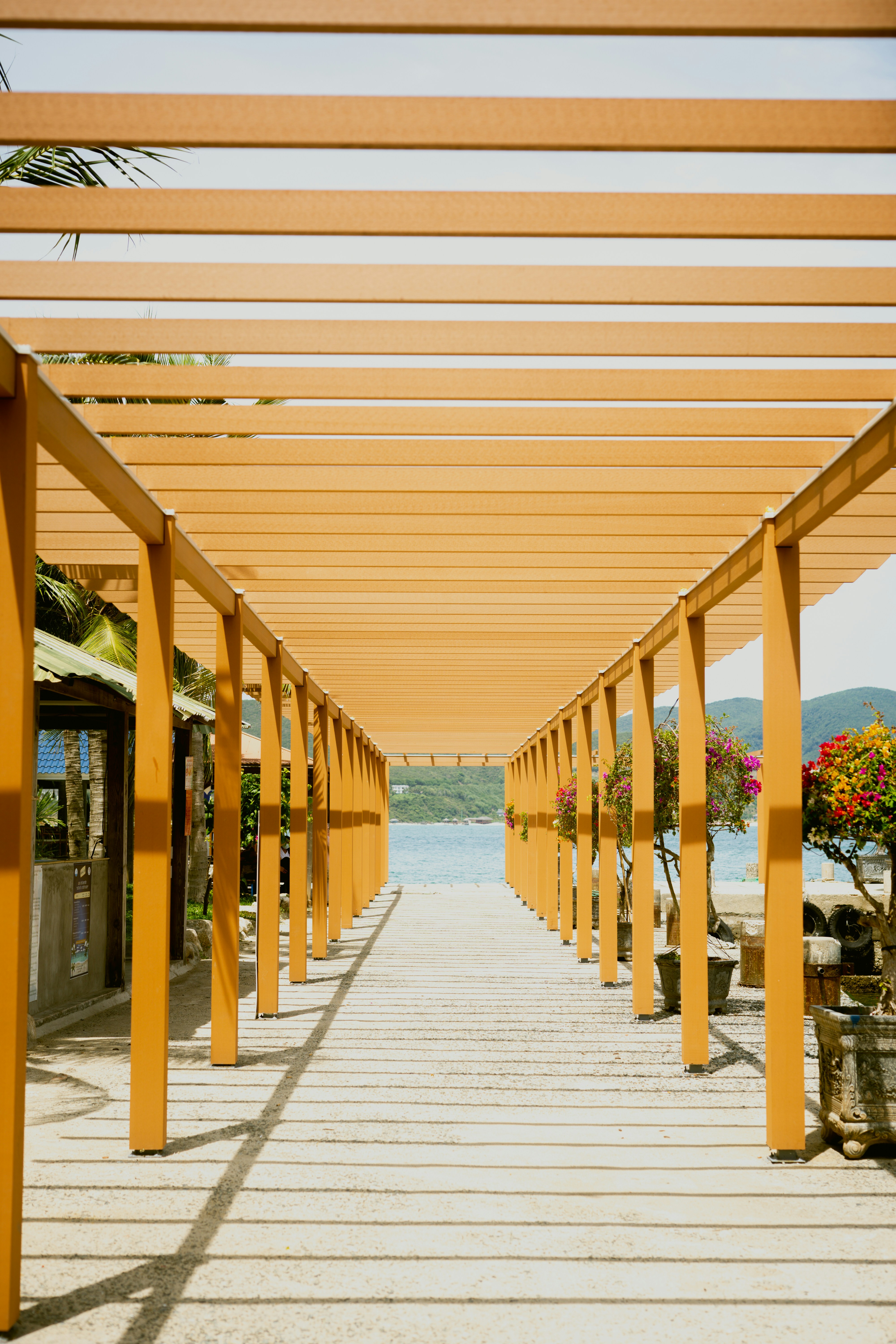 a wooden walkway lined with benches next to a body of water