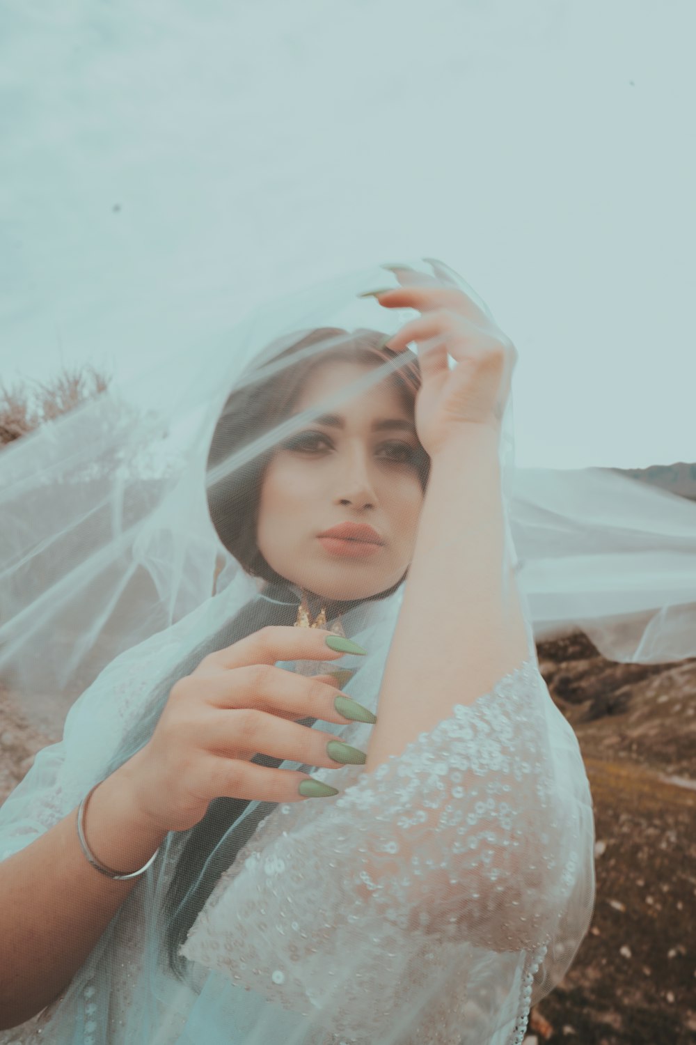 a woman wearing a veil and holding a flower