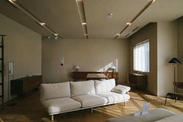 a white couch sitting in a living room next to a window