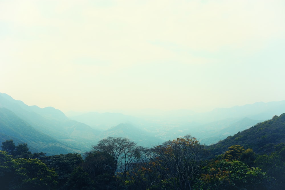 a view of a mountain range with trees and mountains in the background