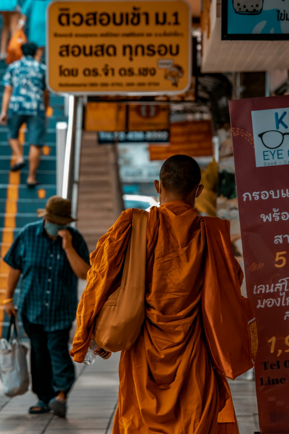 a man walking down a street next to a sign