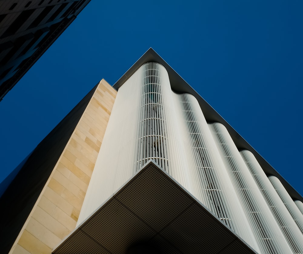 a tall white building with a blue sky in the background