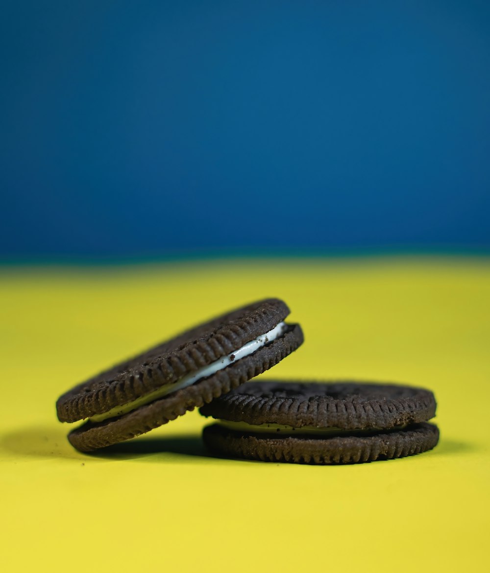 two oreo cookies sitting on top of a yellow table