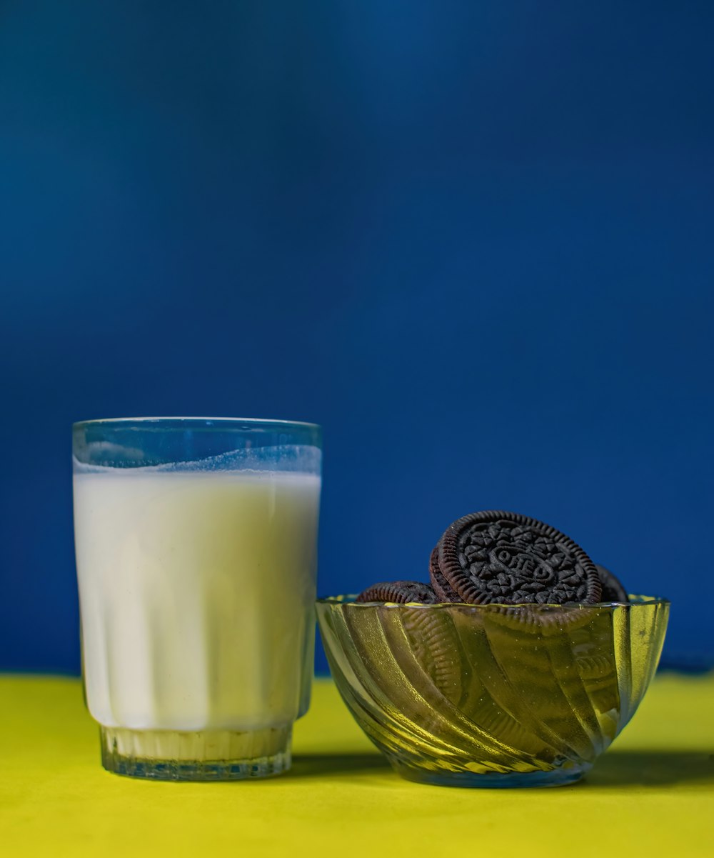 a glass of milk and a cookie on a table
