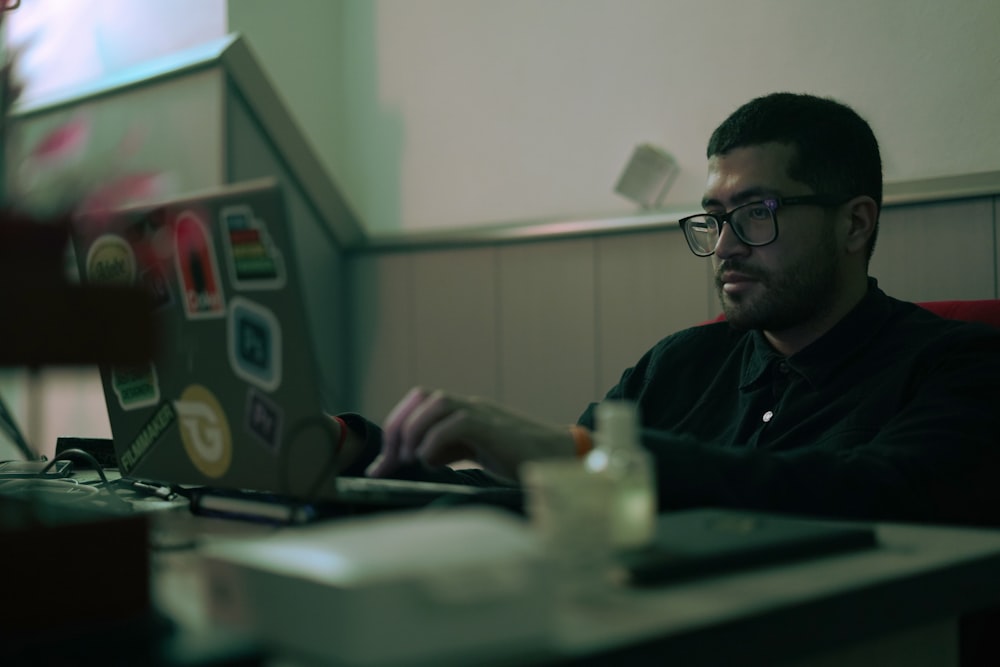 a man sitting at a table using a laptop computer