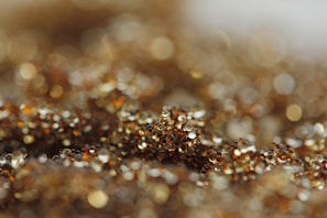 Detailed shot of shimmering gold beads catching the light on a handcrafted purse