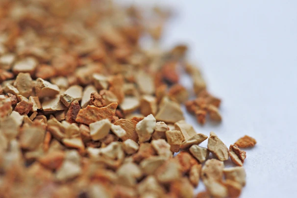 Close-up of soft, clumping cat litter granules in a natural pumpkin color.