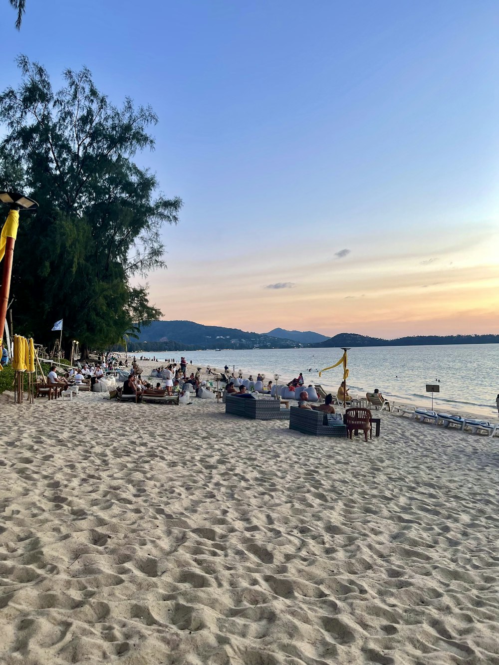 a group of people sitting on top of a sandy beach