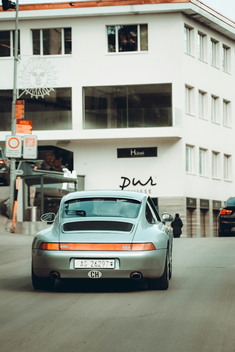 a car driving down a street next to a tall building