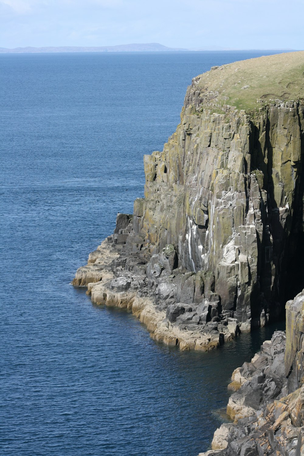 a large body of water next to a rocky cliff