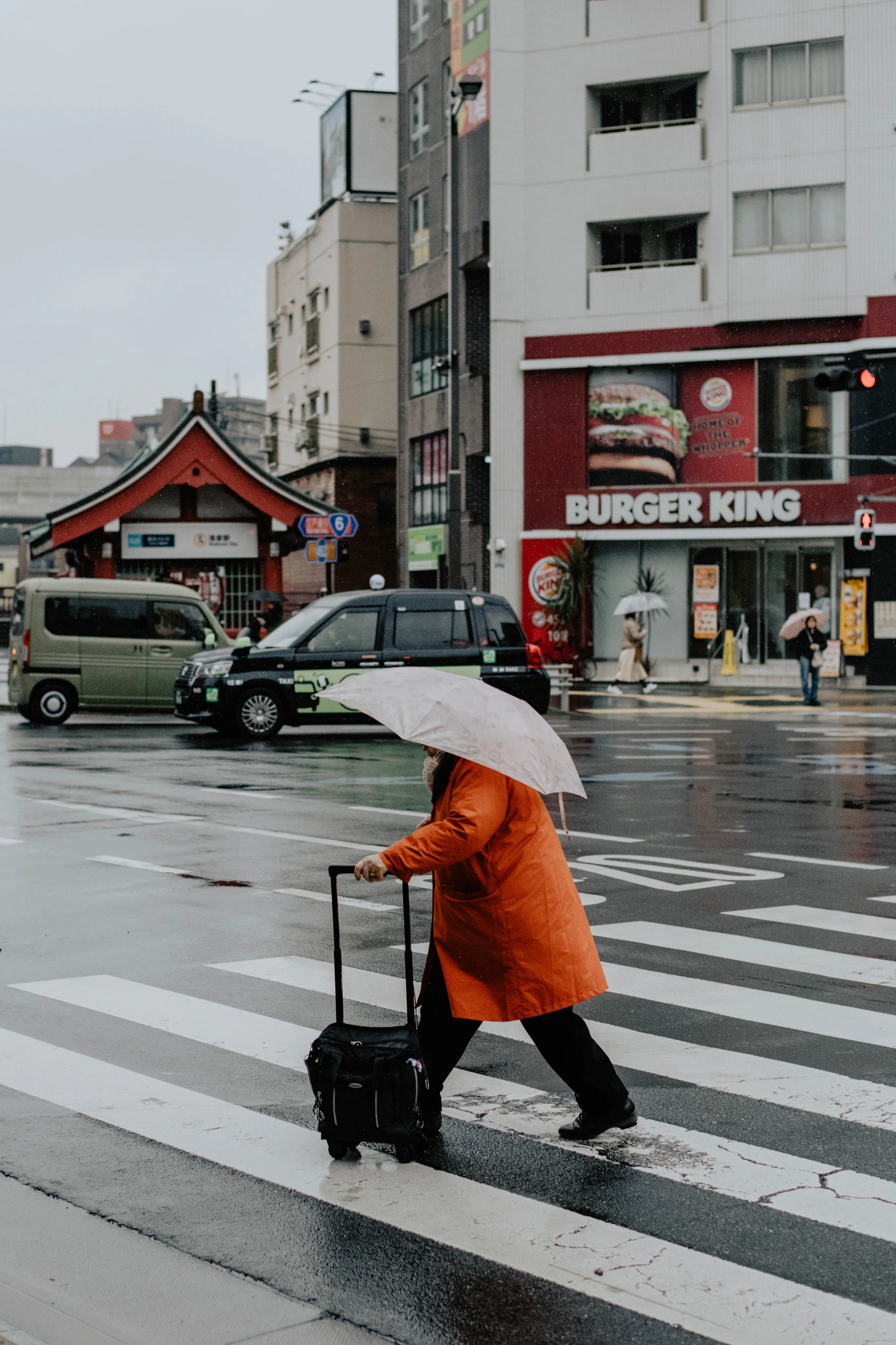 Traveler pulling a suitcase across a city street