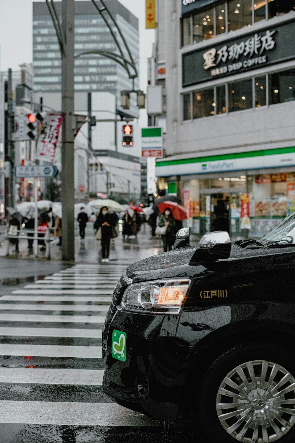 a black taxi cab driving down a street next to tall buildings