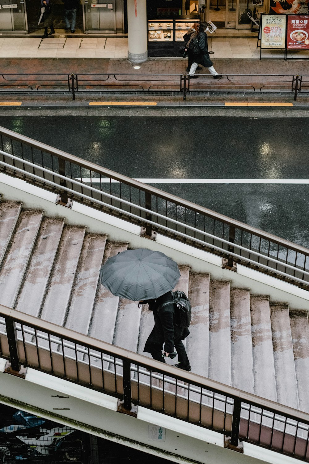 a person with an umbrella walking down a flight of stairs