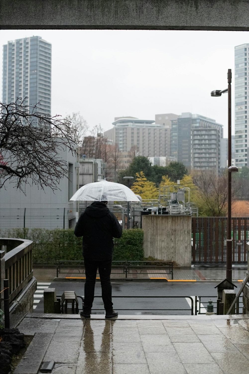 a person standing under an umbrella in the rain