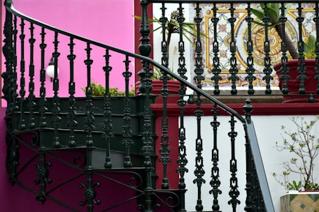 a stair case next to a pink wall