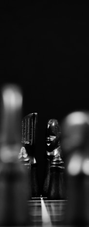 An artistic black and white photo focusing on the shadows and curves of a totem carving, evoking mystery.