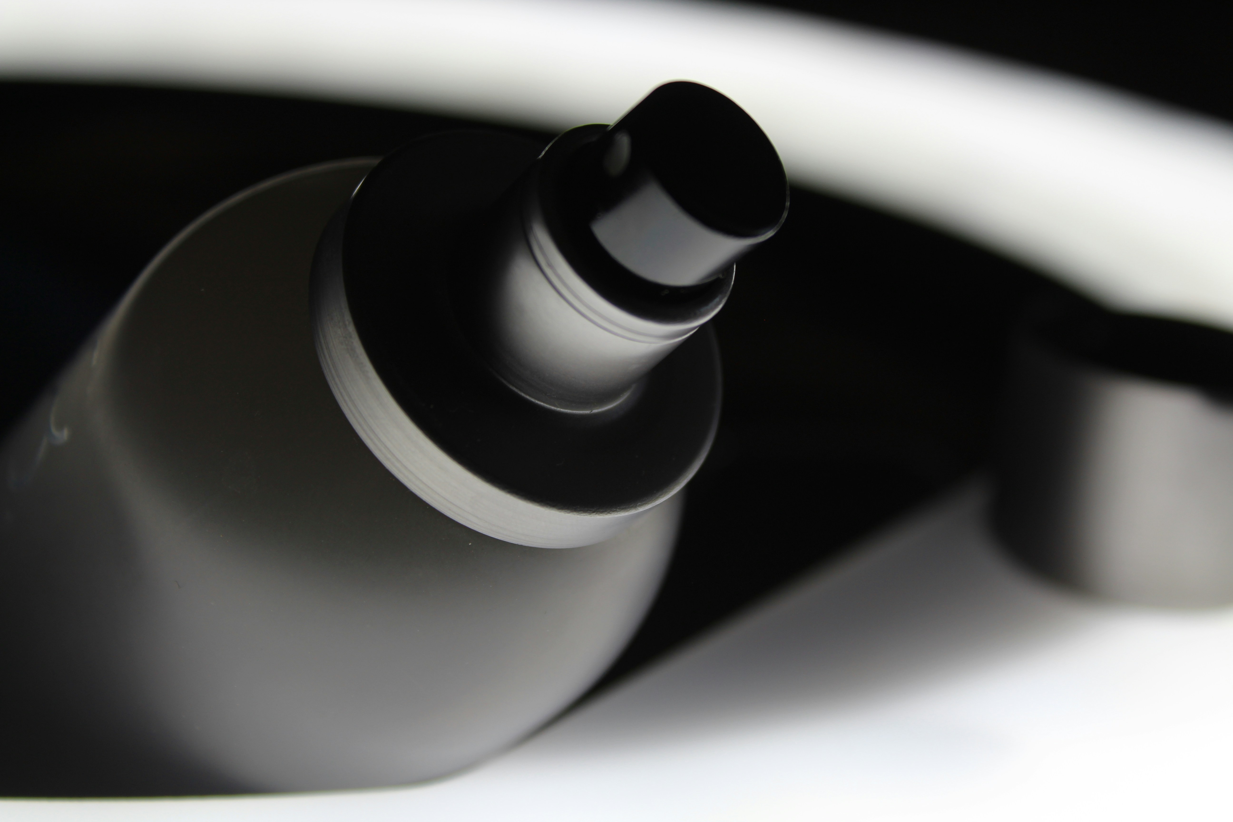 Close detail shot of the Vessel bottle lid and seal mechanism, clean macro photography, white studio background
