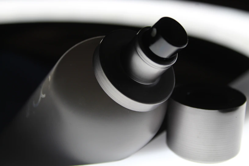 Close-up of a sleek, professional paint sprayer nozzle with droplets of fresh paint ready to spray.