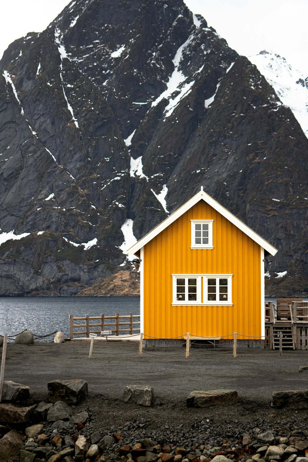 a yellow house with a mountain in the background