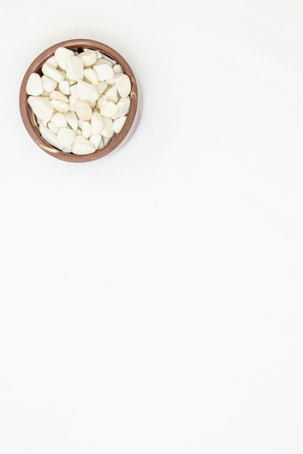 a bowl filled with white rocks on top of a table