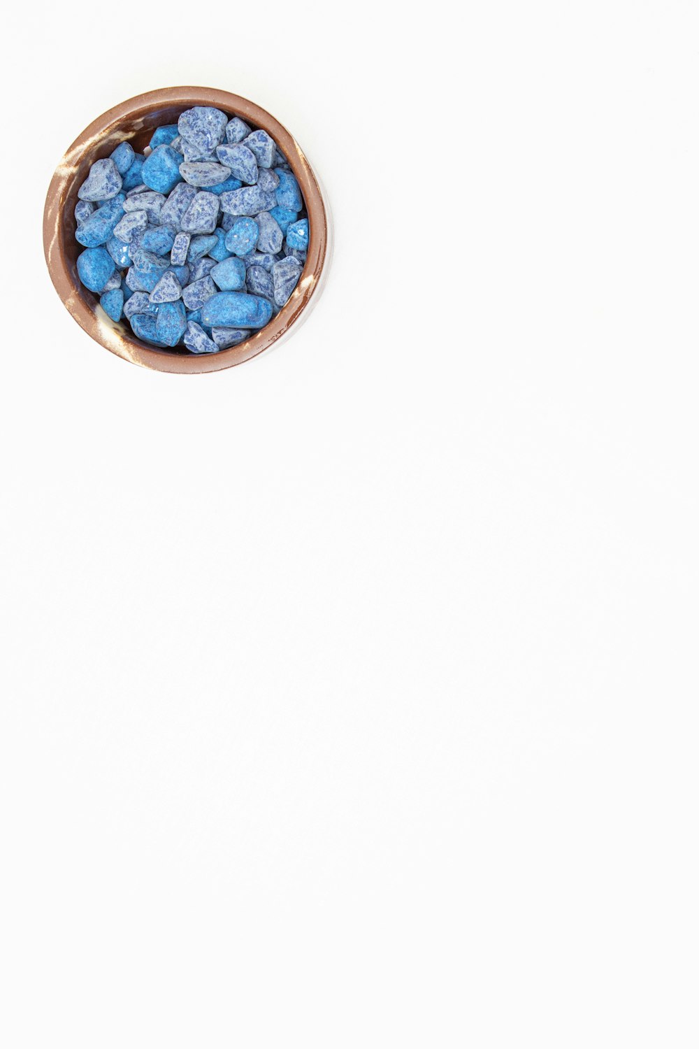 a bowl filled with blue candy sitting on top of a table