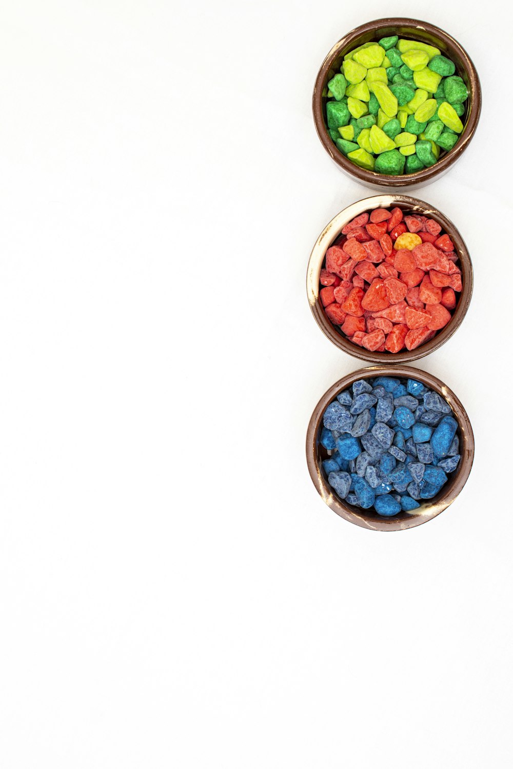 three bowls filled with different colored candies