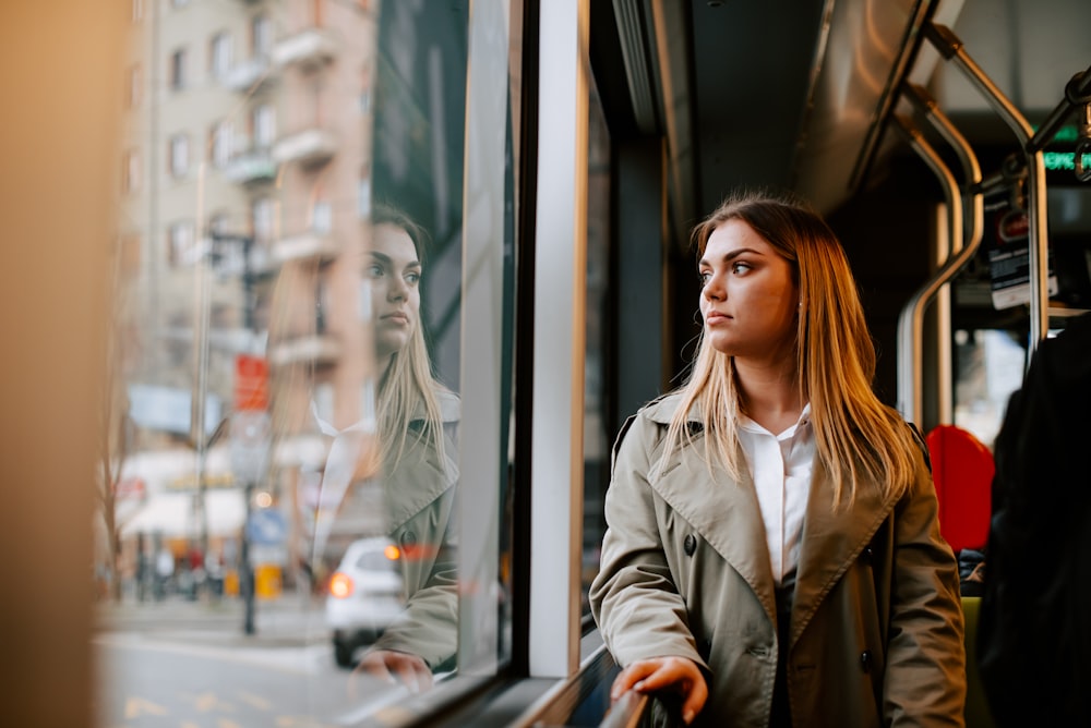 a woman standing on a bus looking out the window