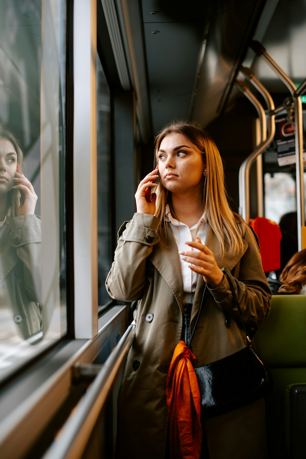 a woman is talking on a cell phone on a train