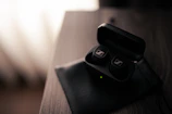 Wireless earbuds resting on a charging case with soft natural light highlighting details.