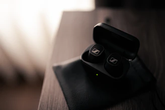 Sleek wireless earbuds resting on a charging pad with soft natural light highlighting their design.
