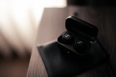 Wireless earbuds resting on a charging case with soft natural light highlighting details.