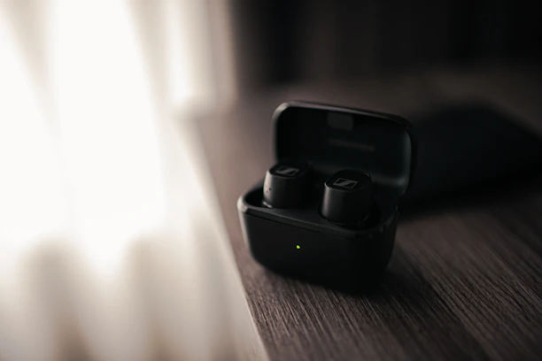 Close-up of sleek wireless earbuds resting on a modern wooden table with soft natural light.