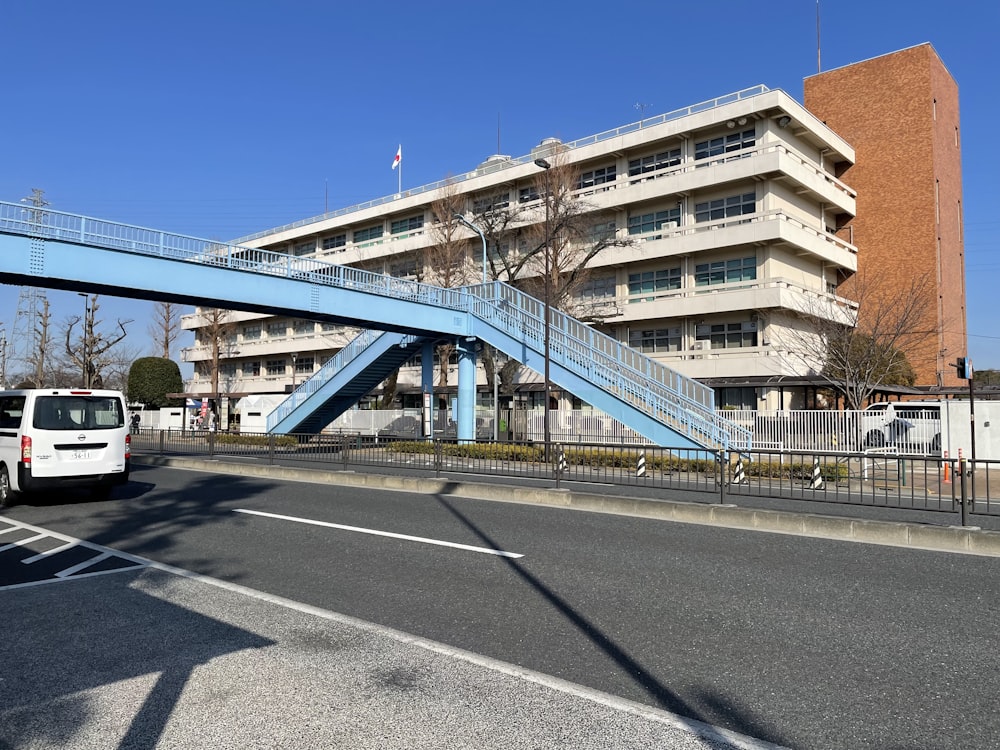 a white van driving under a blue bridge