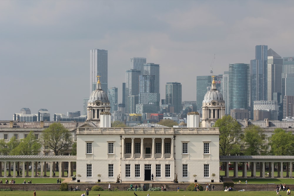 a large white building in front of a large city