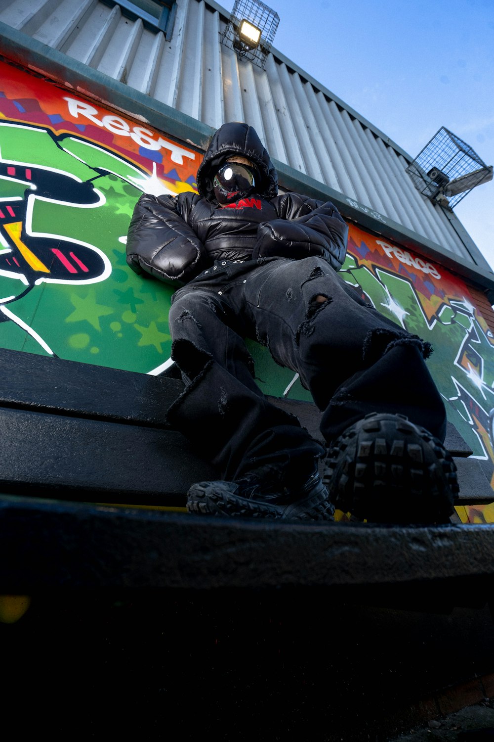 a man sitting on top of a skateboard ramp