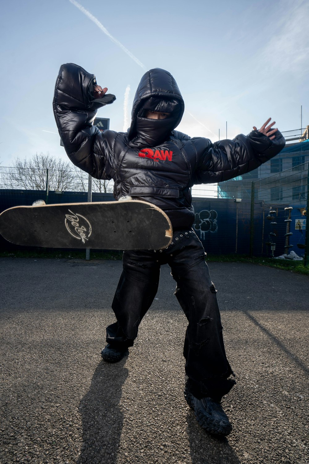 a person in a leather jacket holding a skateboard