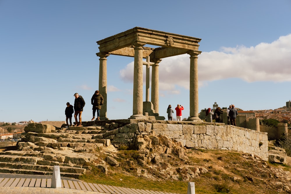 a group of people standing on top of a stone structure
