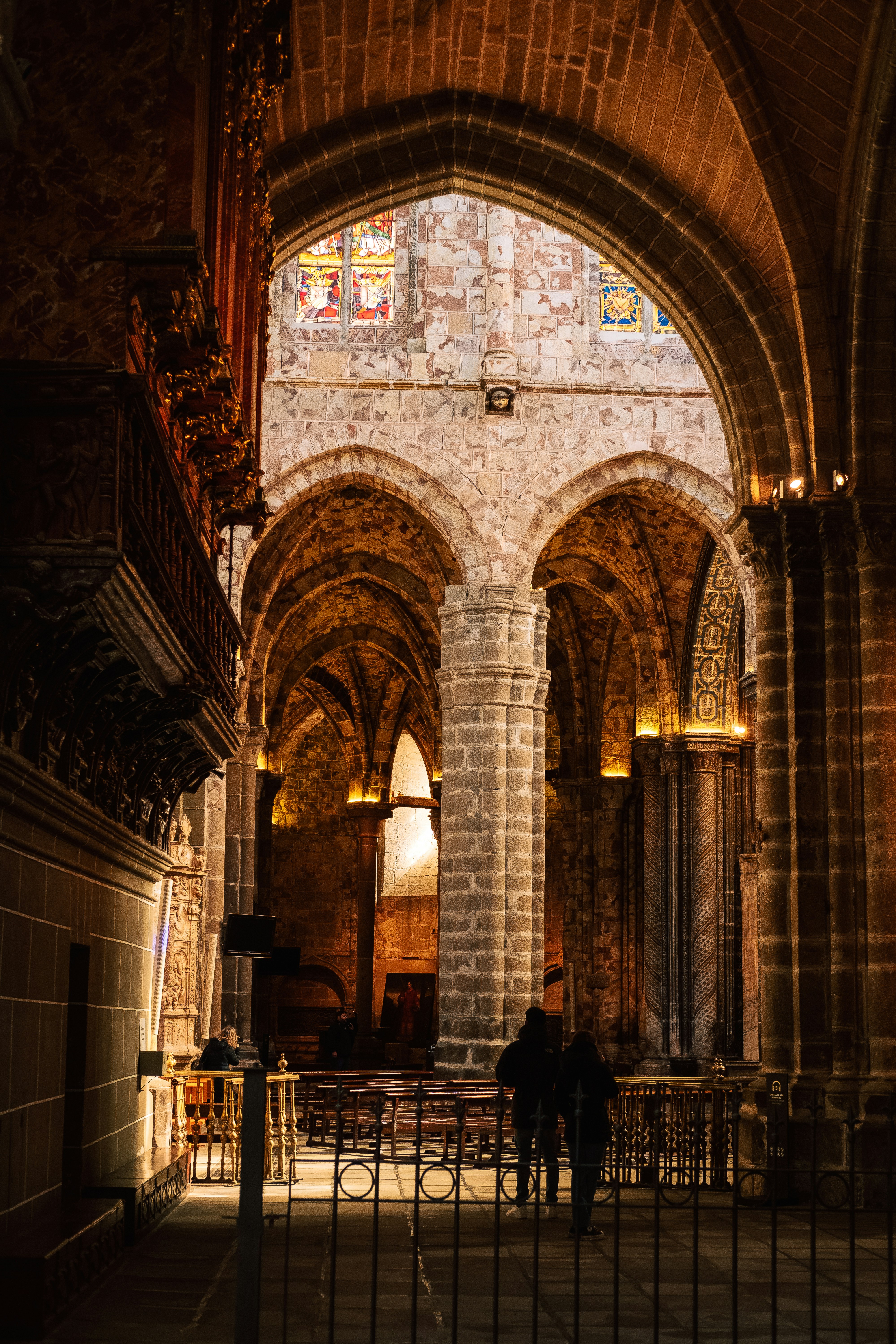 Sunlight through stained glass in a grand cathedral, golden light on stone pillars, reverent atmosphere
