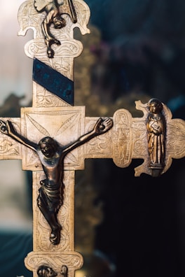 Black and gold handcrafted ornate cross illuminating rich textures and fine details.