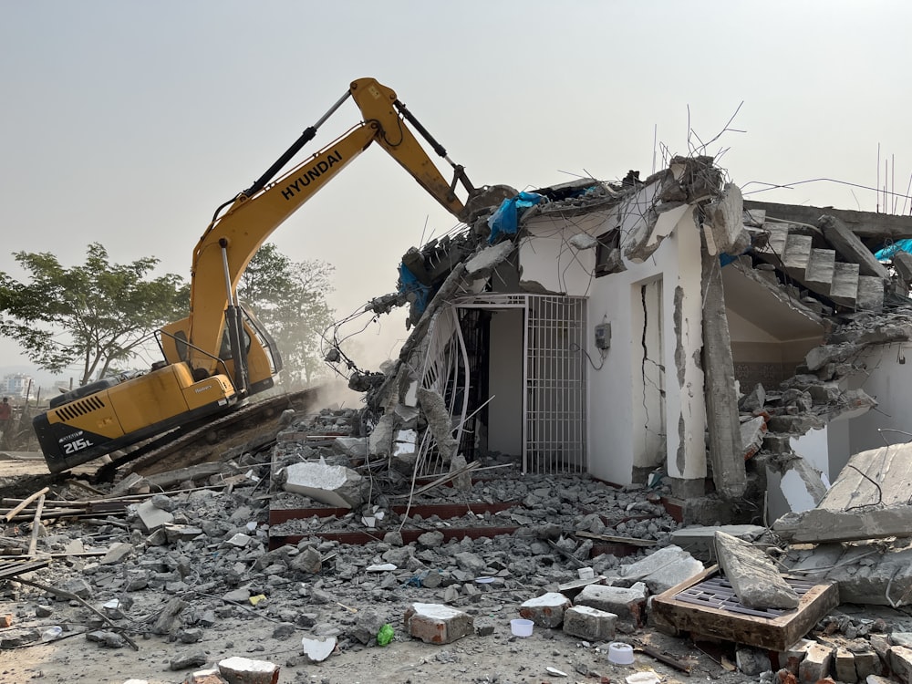 Ein Bulldozer gräbt sich durch ein abgerissenes Gebäude