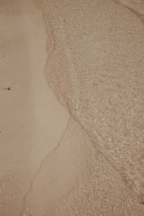 a person walking on a beach with a surfboard