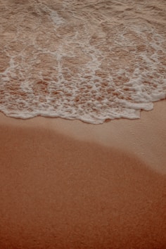 a sandy beach with waves coming in to shore